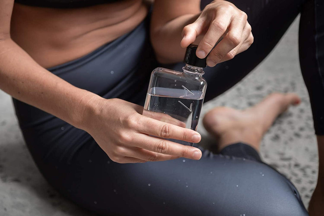 A woman holding the A7 Memobottle 180ml Flat Water Bottle